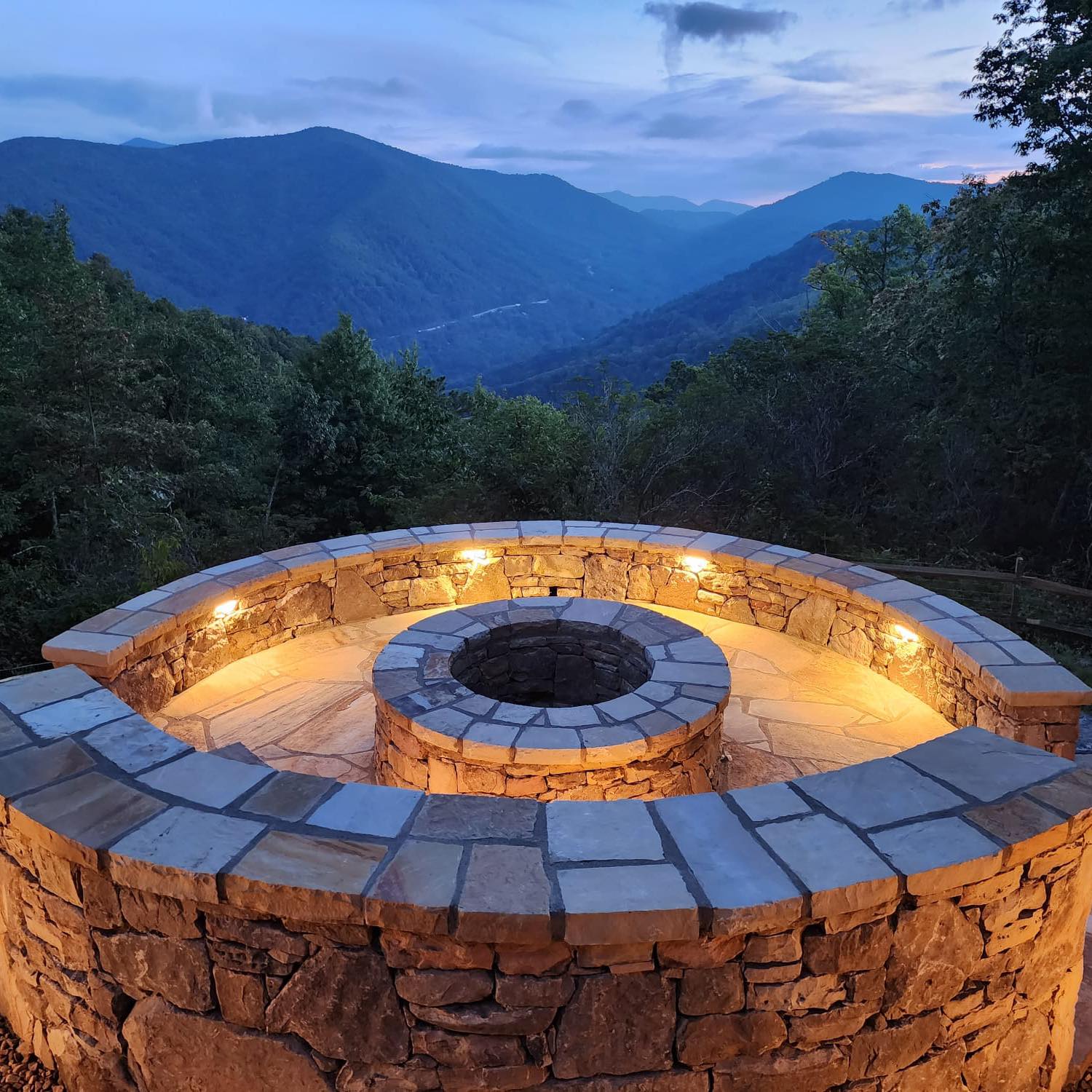 Nighttime stone fire pit and outdoor seating area