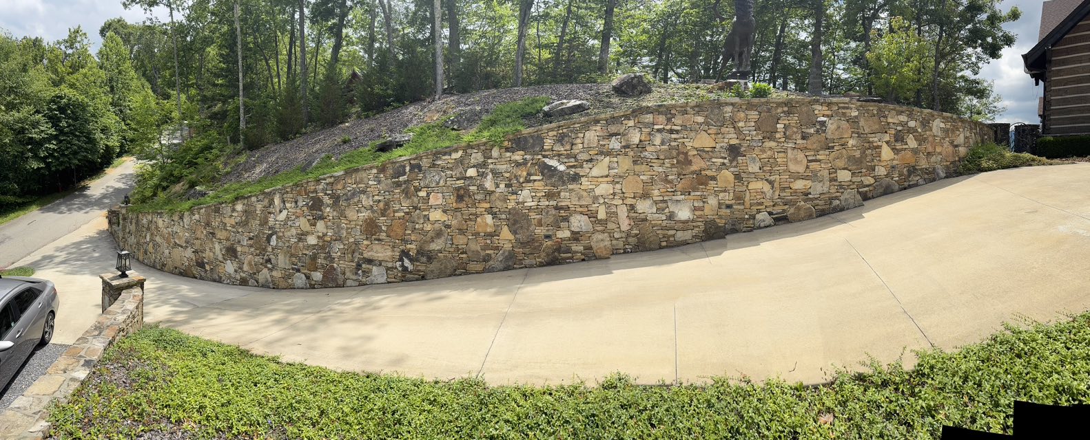 Stone retaining wall beside driveway