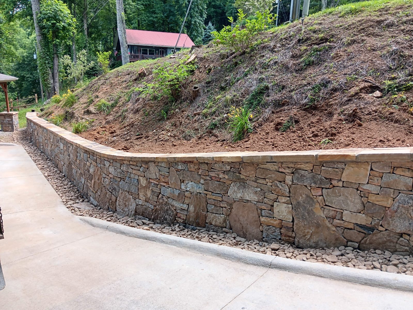 Stone retaining wall beside a driveway